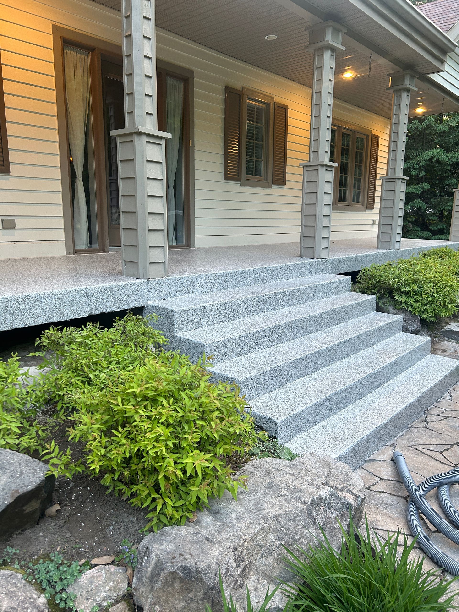 Une maison avec un porche et des escaliers qui y mènent.