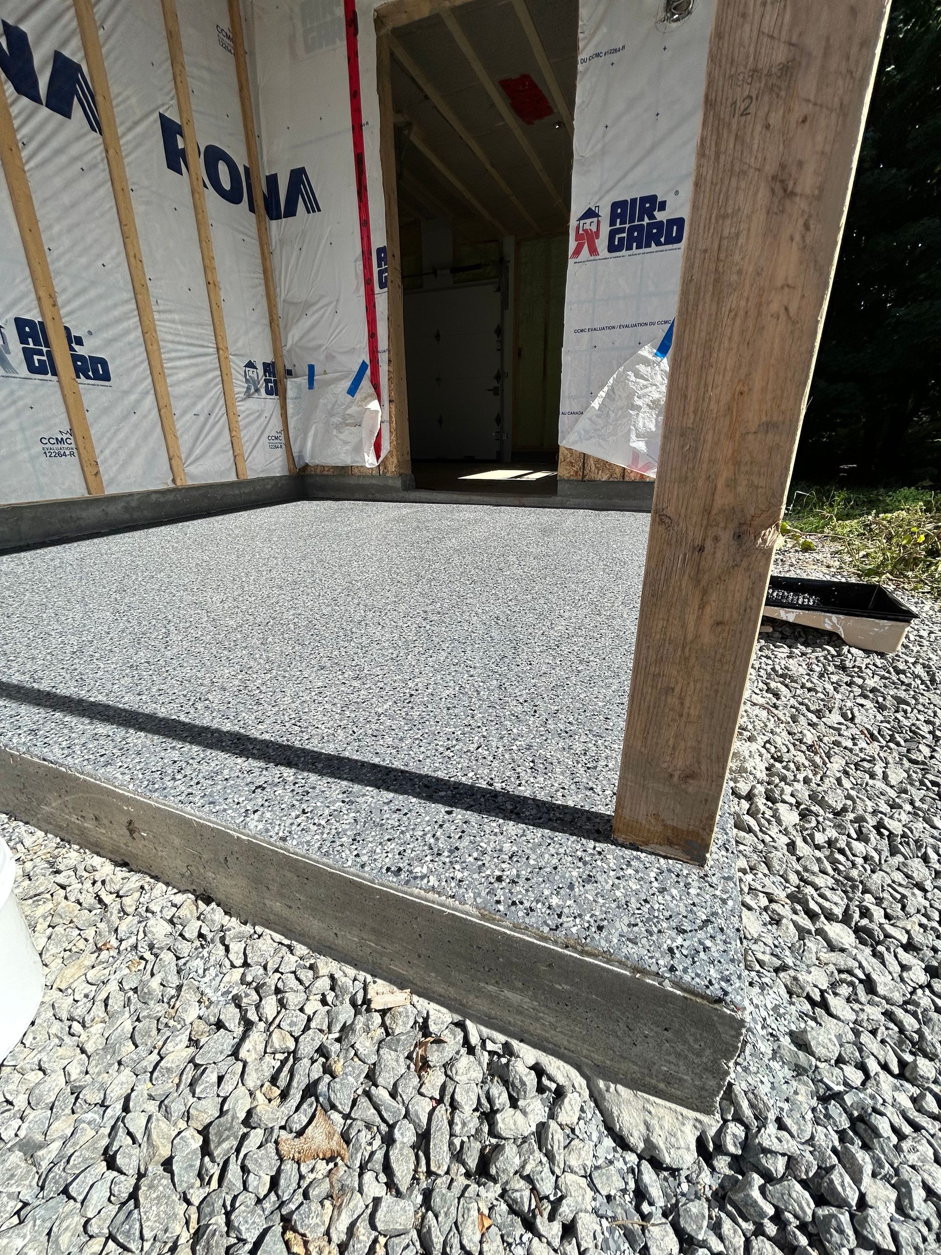 Un tas de gravier se trouve devant un bâtiment en construction.