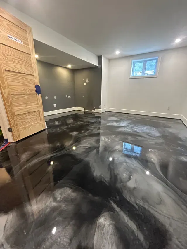 Un sous-sol avec un sol en époxy noir et argent.