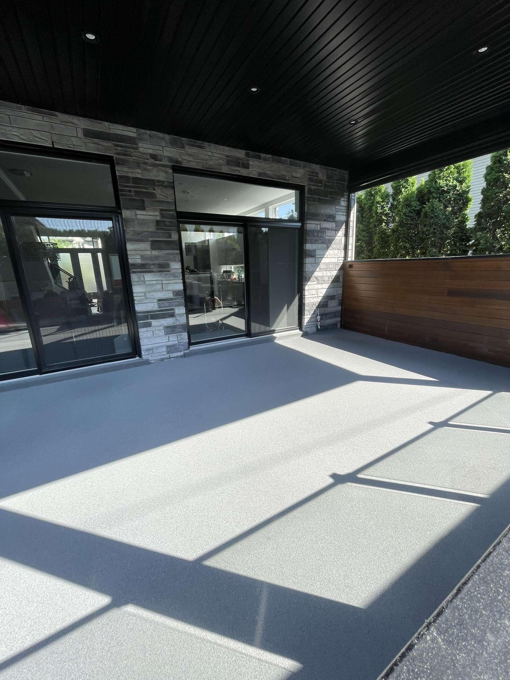 Une pièce avec un sol en béton et des murs blancs.