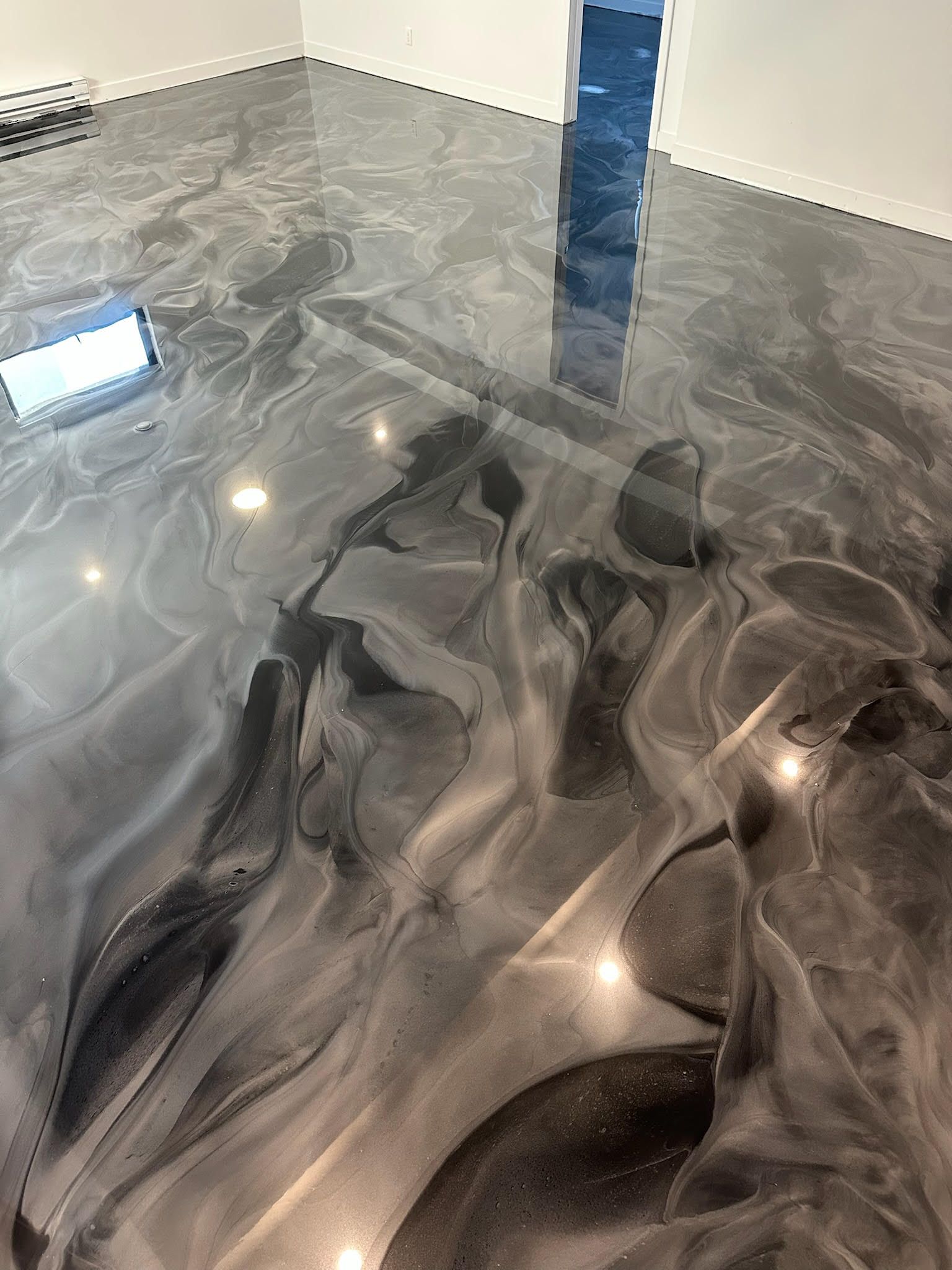 Une pièce avec un sol brillant et un mur noir.