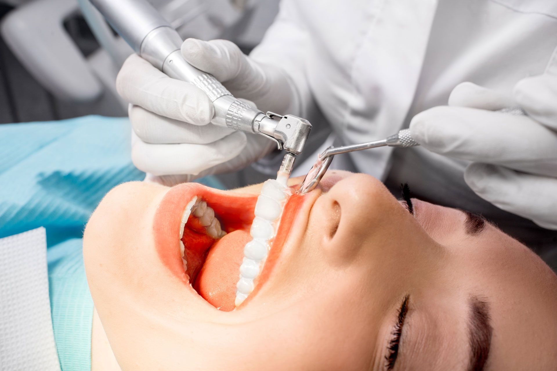 A woman is getting her teeth cleaned by a dentist.