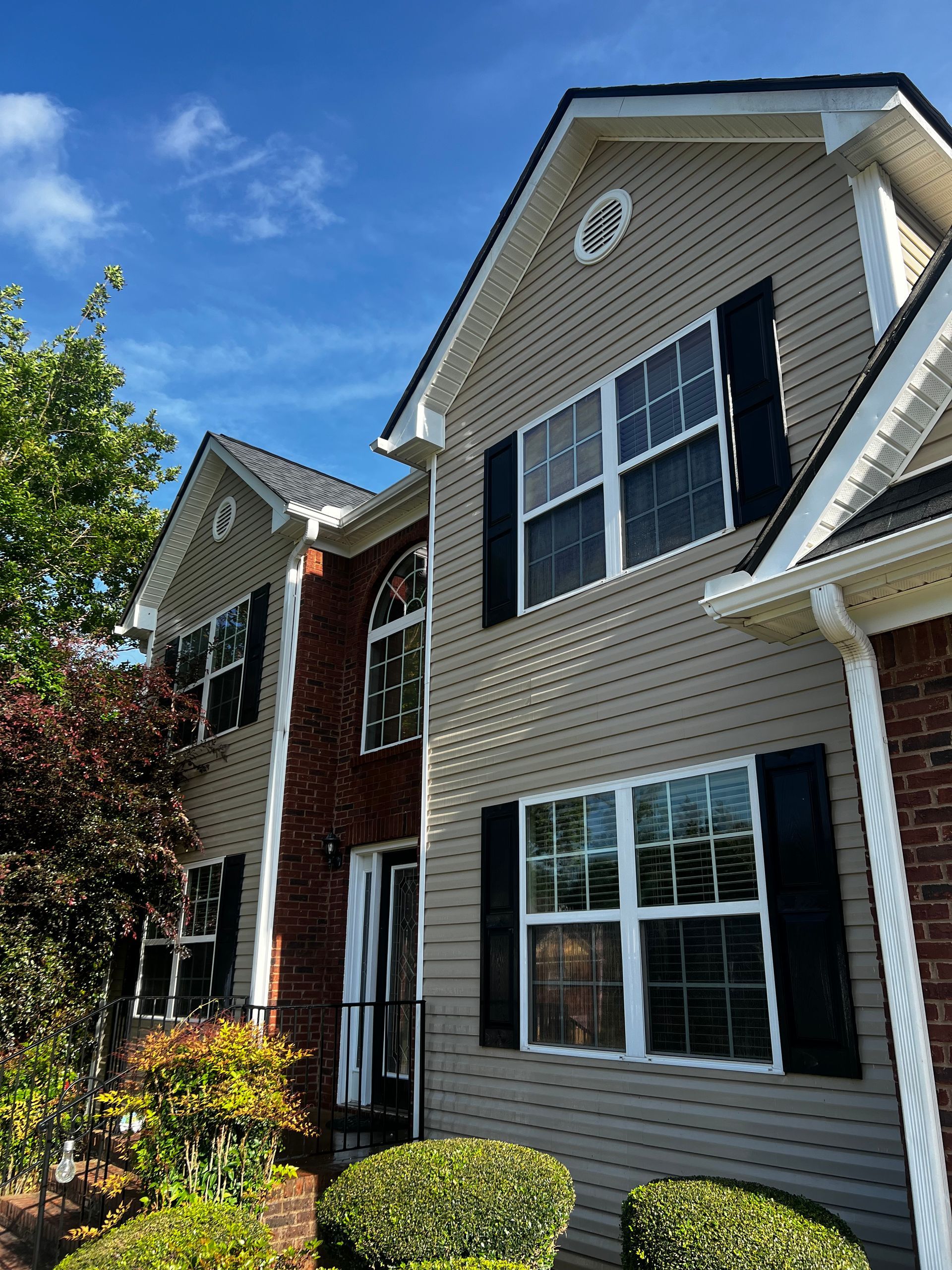 A large house with a lot of windows and black shutters