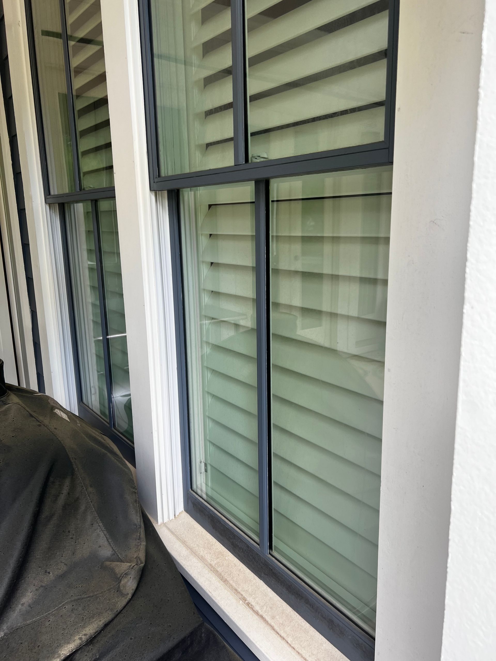 A close up of a dirty window with blinds on it