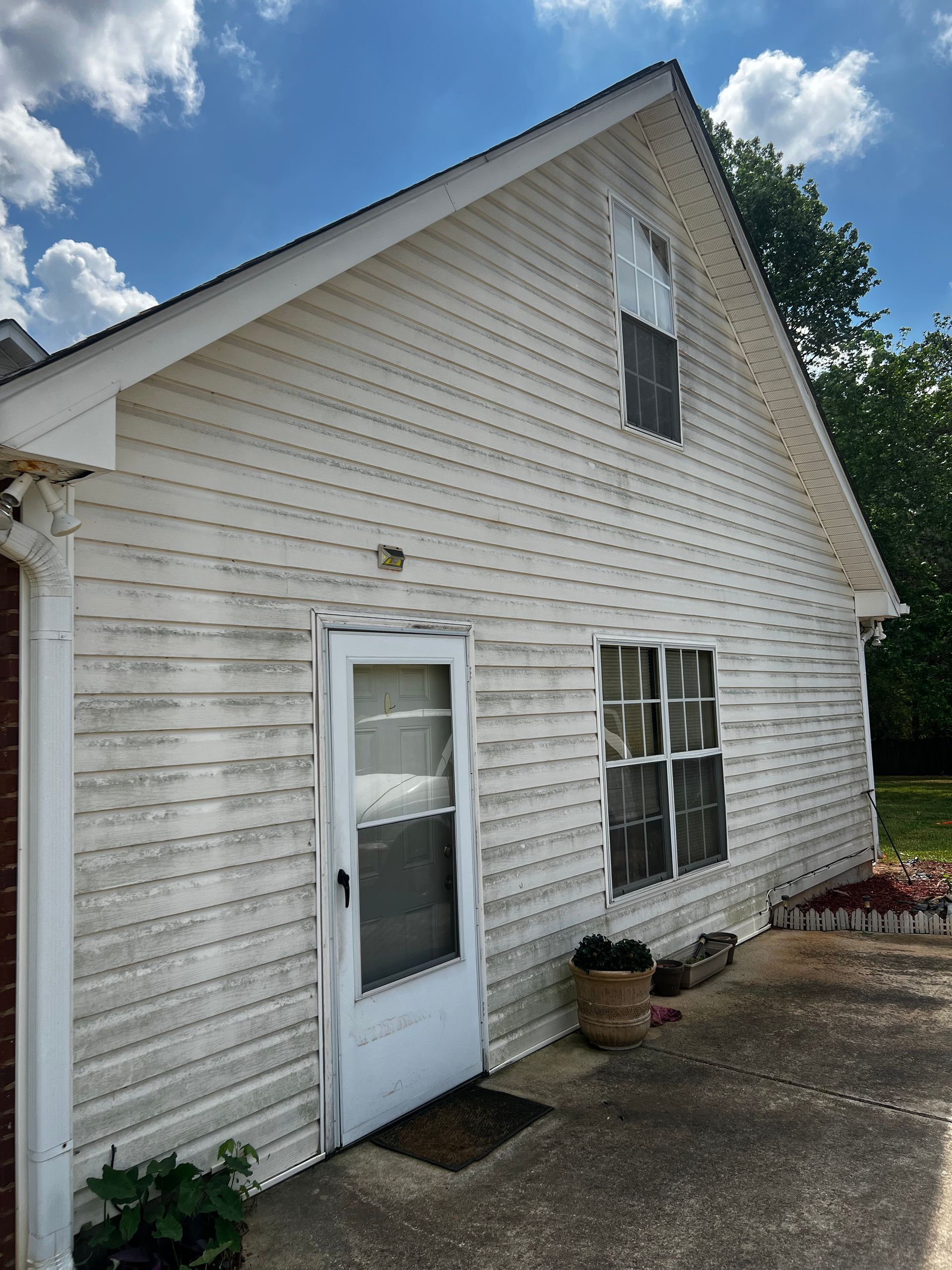 A house with a dirty siding and a dirty door