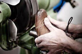Shoemaker polishing sole of shoe - Dry Cleaner Alterations in Champaign-Urbana, IL