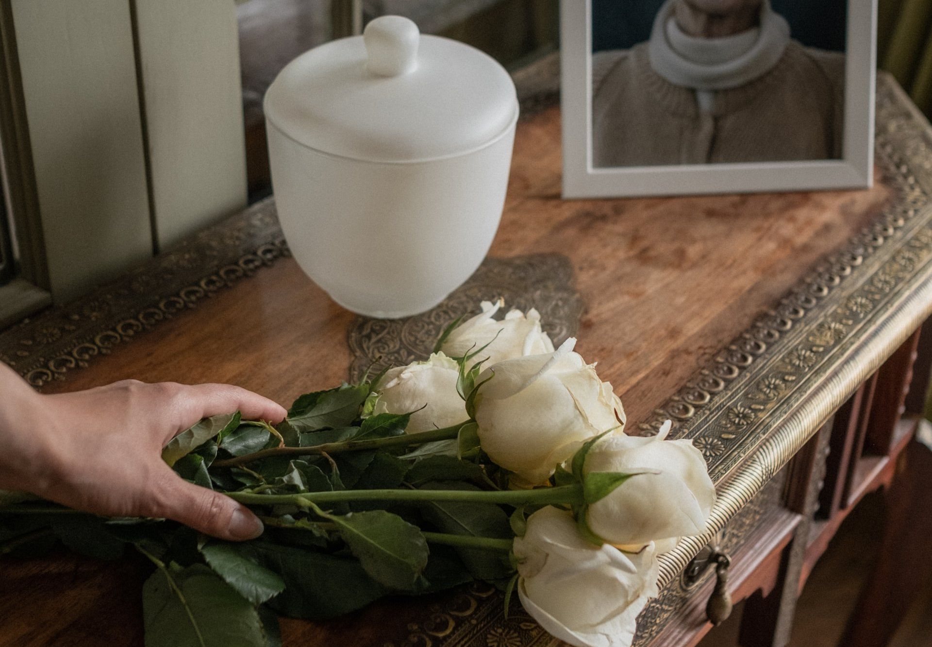a person holds a bouquet of white roses on a table