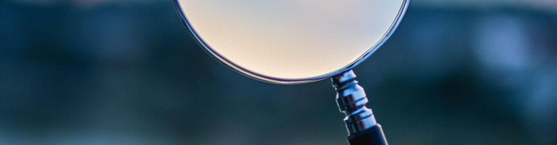 a close up of a magnifying glass with a blue background