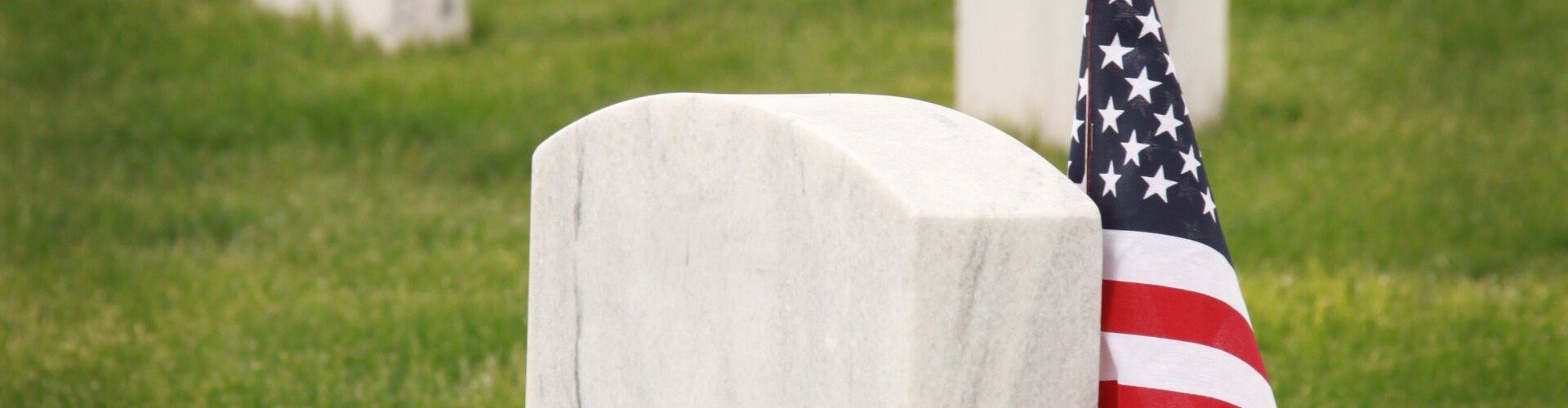 a grave with an american flag in front of it