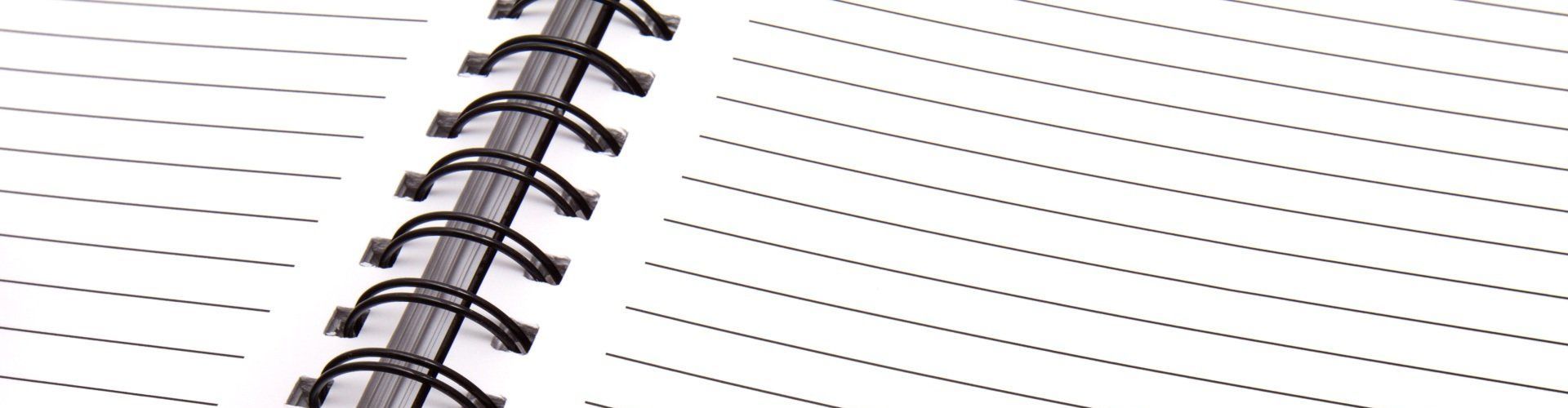 a close up of a spiral notebook with lines on it