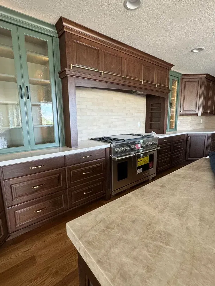 A kitchen with wooden cabinets , stainless steel appliances , and a large island.