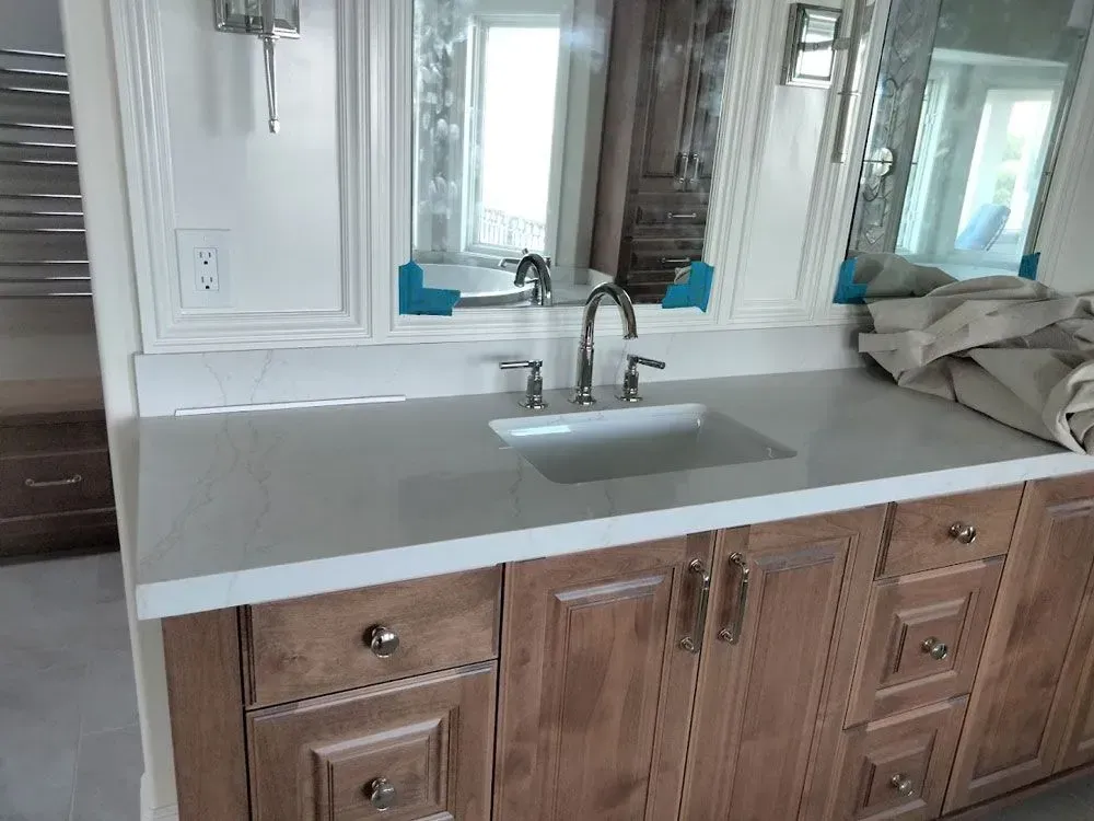 A bathroom vanity with a sink and two mirrors