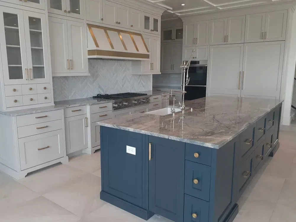 A kitchen with a large island in the middle and white cabinets.