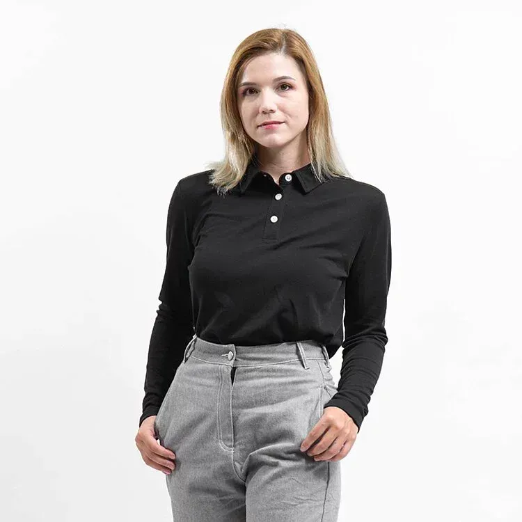 一名女子身穿黑色 Polo 衫和灰色褲子。