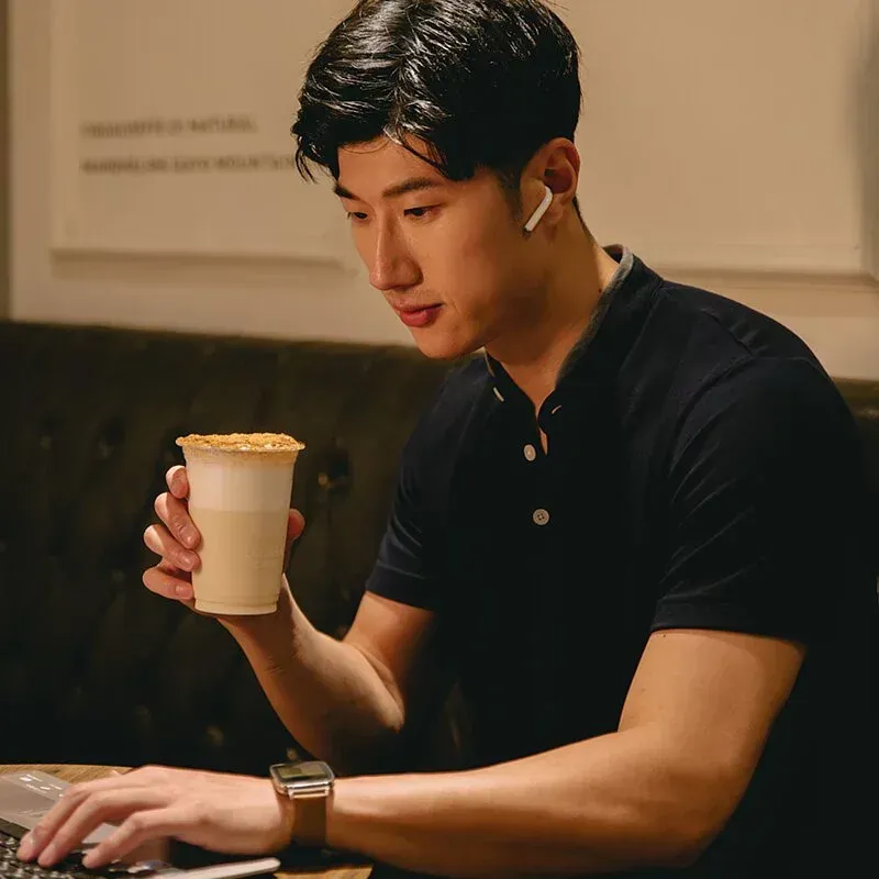 一位男士坐在桌邊，手裡拿著一杯咖啡