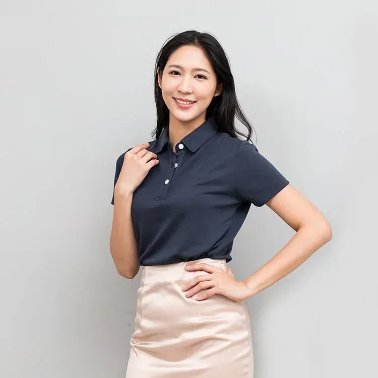 一名女子身穿藍色 Polo 衫和粉紅色裙子。