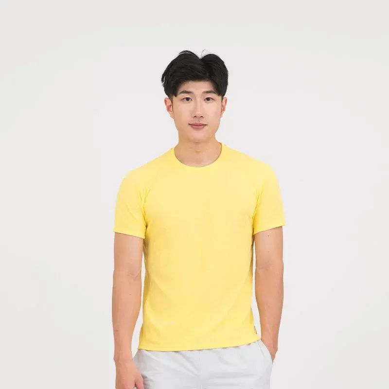 一名年輕男子身穿黃色 T 恤和灰色短褲。