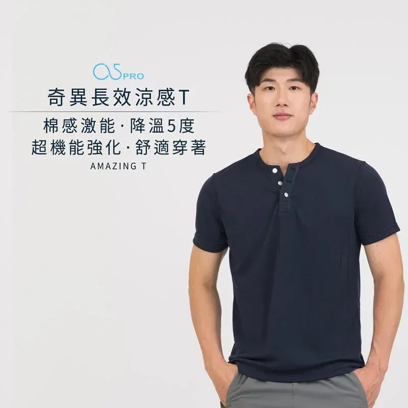 一名身穿藍色 T 恤的男子站在那裡，雙手插在口袋裡。