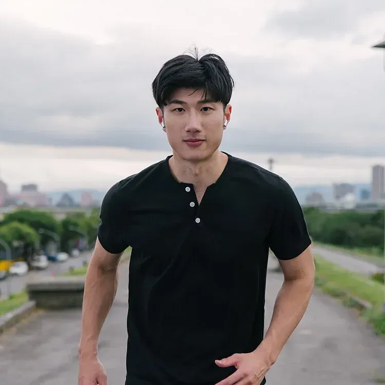 一名身穿栗色襯衫的男子肩上扛著一隻橘色籃球。