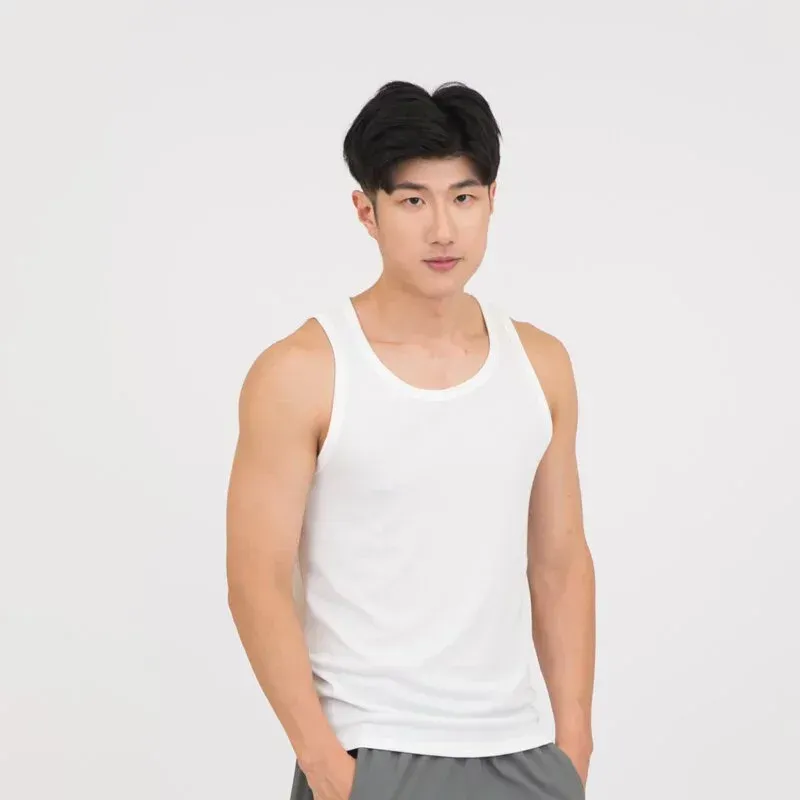 一名身穿黃色背心的年輕人雙手插在口袋中站著。