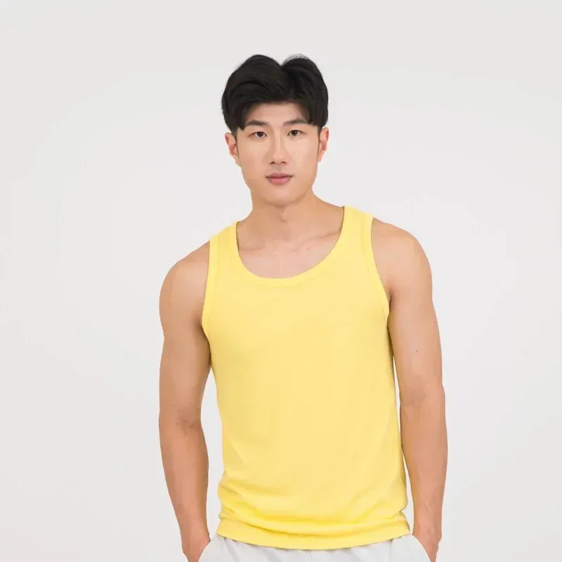 一名身穿黃色背心的年輕人雙手插在口袋中站著。