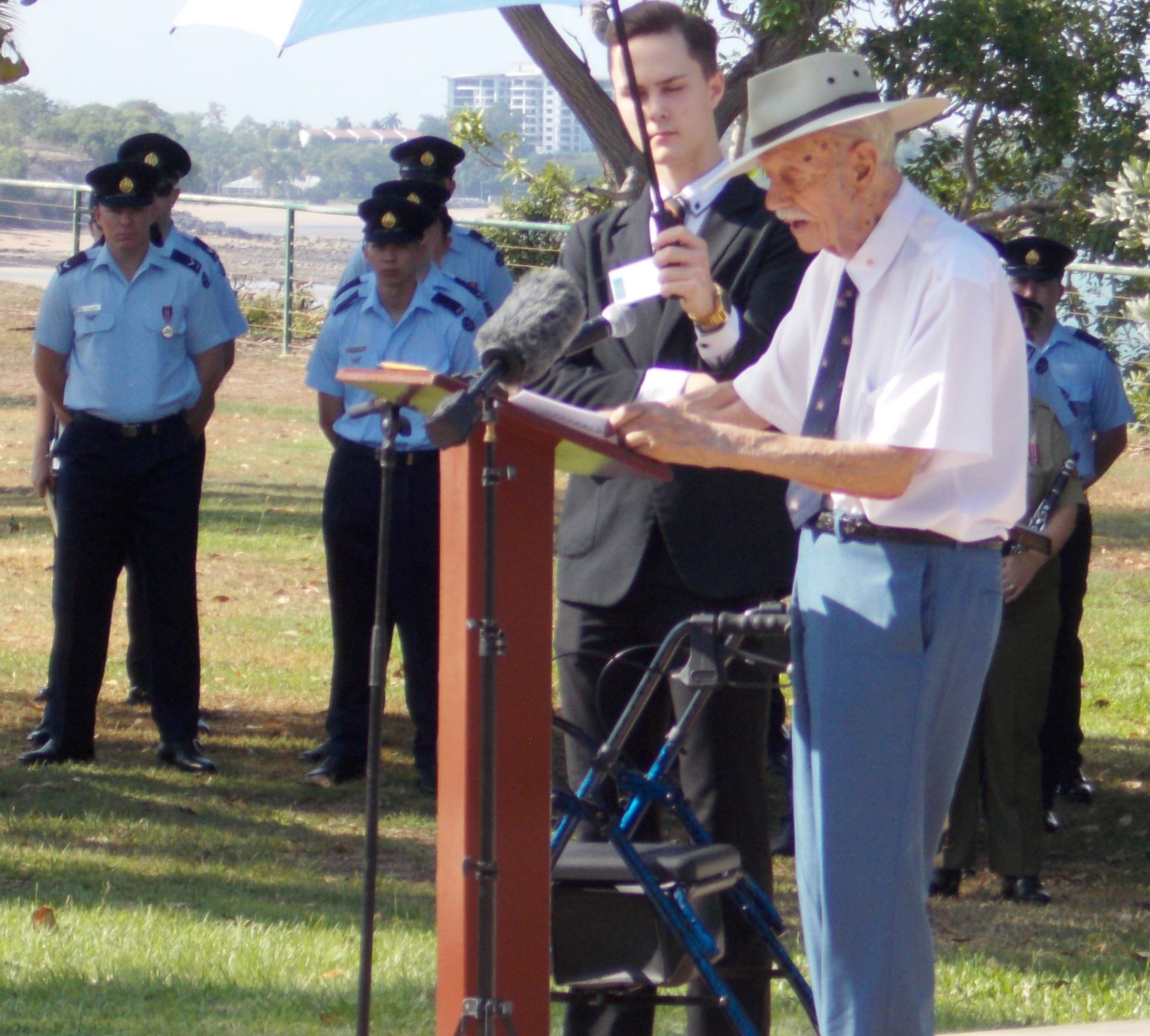 A man in a hat is giving a speech at a podium