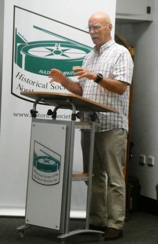 A man stands at a podium with a sign that says historical society