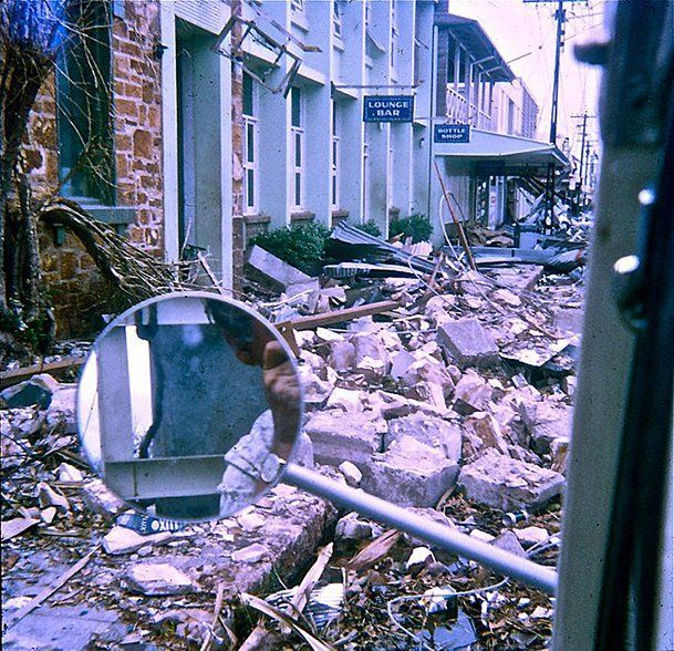 A reflection of a building in a mirror in a pile of rubble