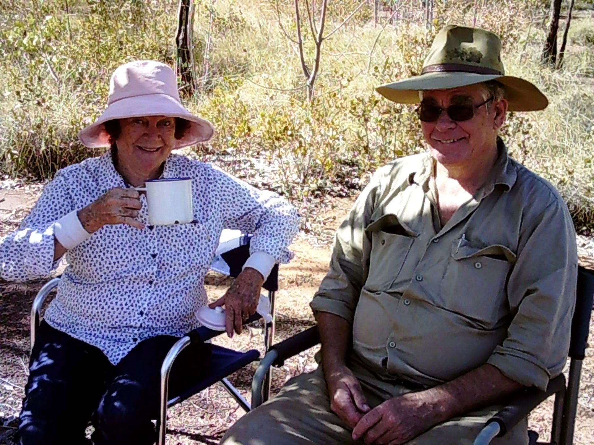 A man and a woman are sitting in chairs drinking coffee