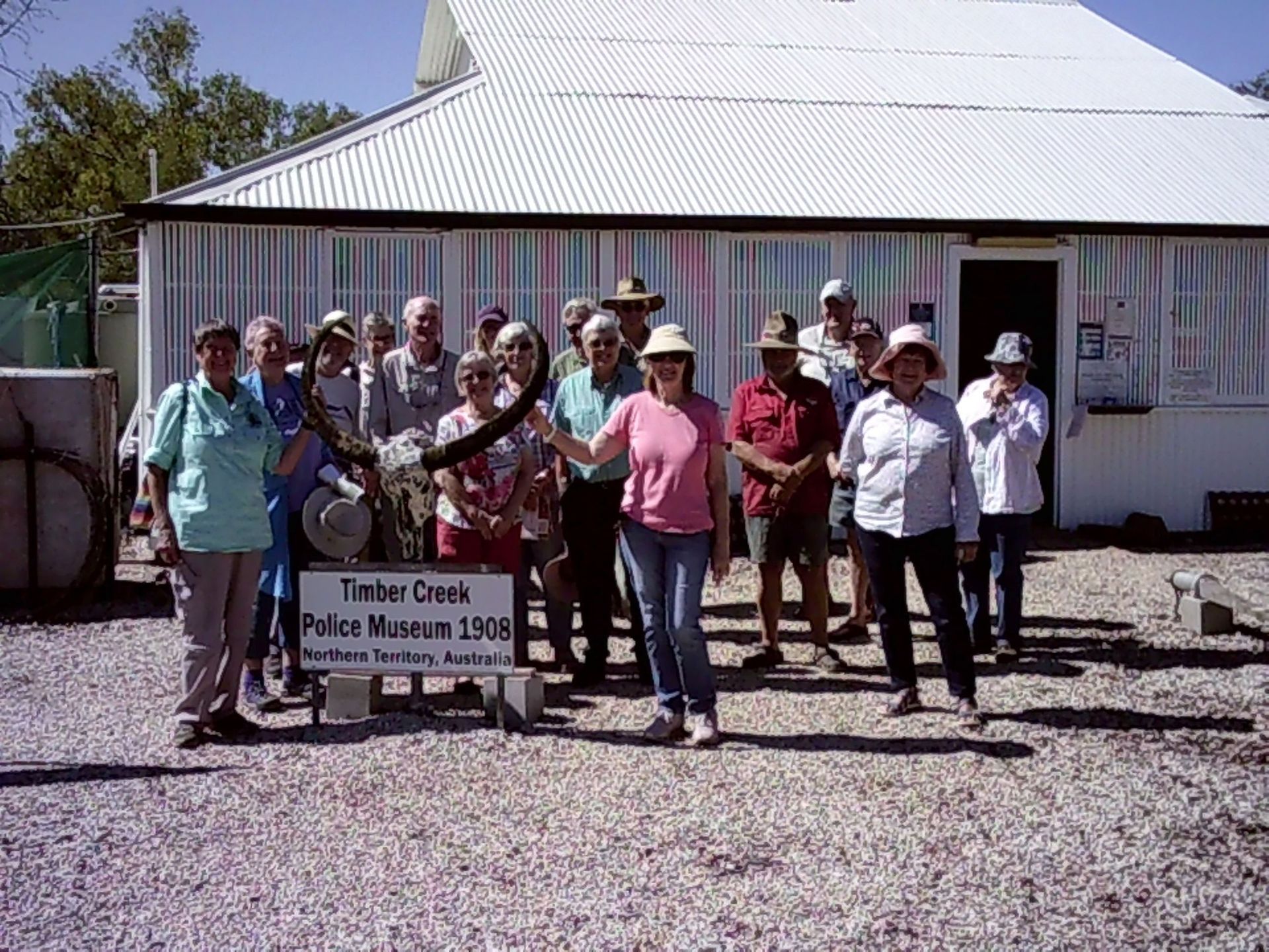 A group of people standing in front of a sign that says timber creek police museum