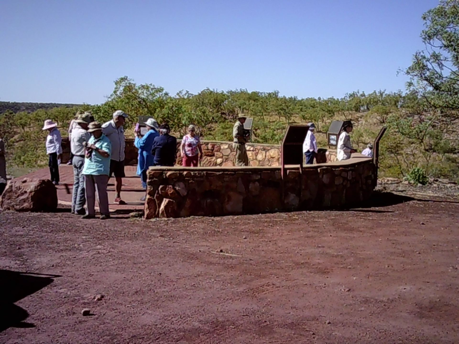 A group of people standing around a stone wall
