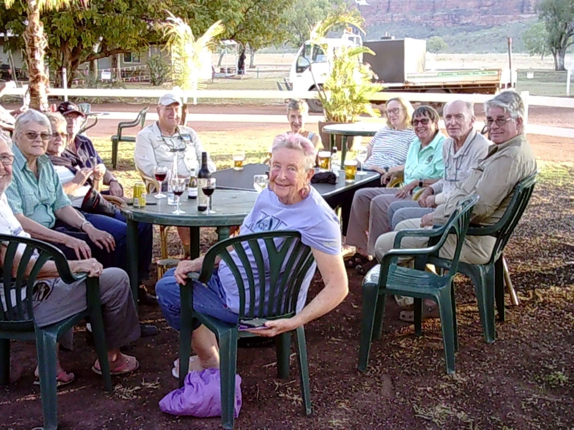 A group of people are sitting around a table with wine glasses