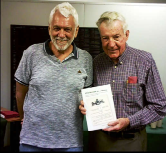 Two men standing next to each other holding a piece of paper