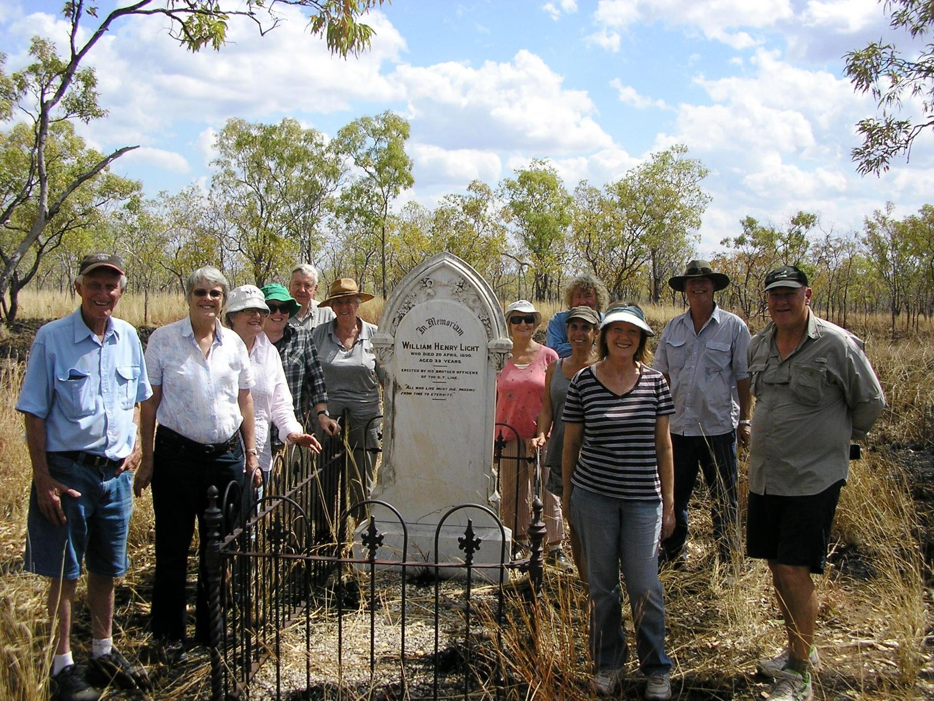 A group of people standing in front of a grave