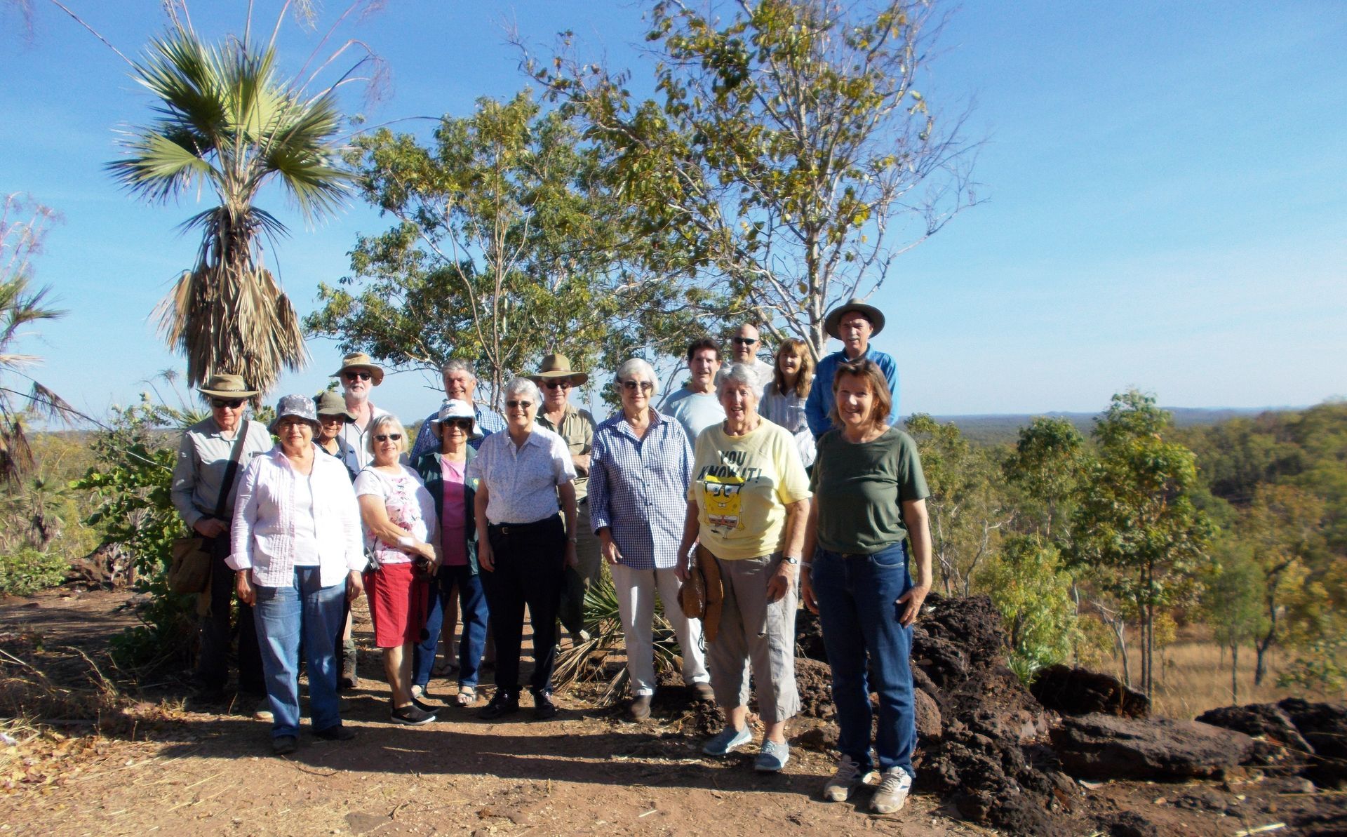 A group of people posing for a picture in front of trees
