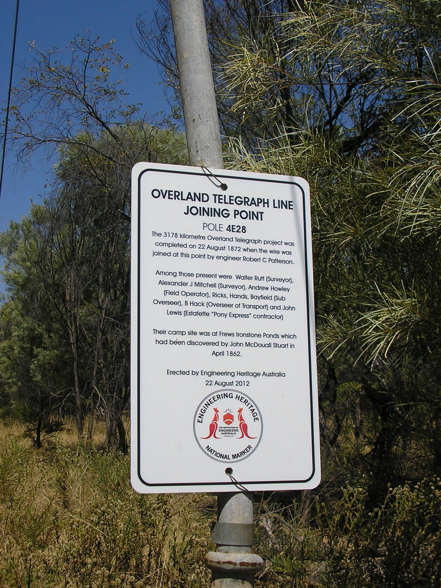 A sign on a pole that says overland