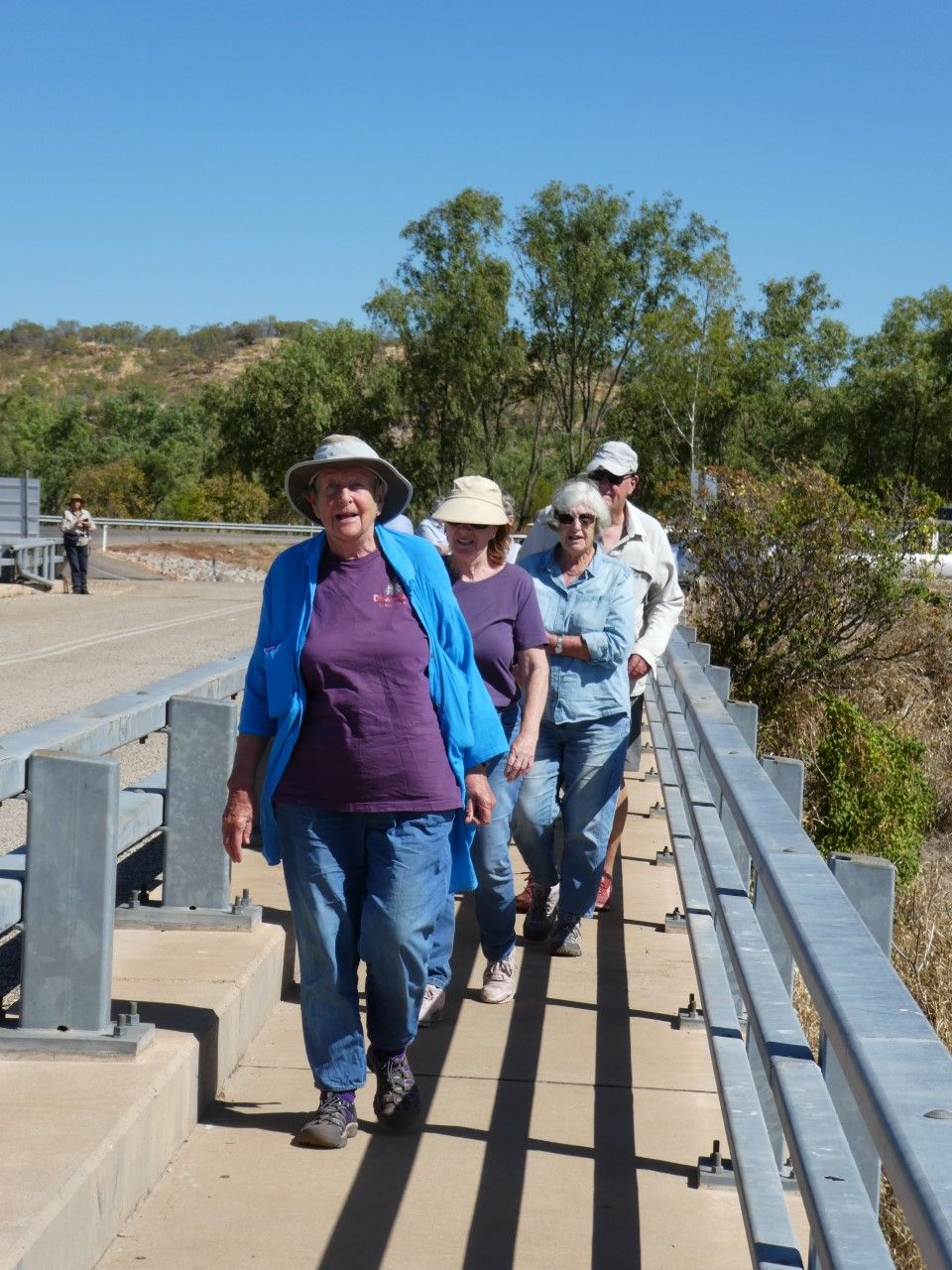 A group of people are walking across a bridge