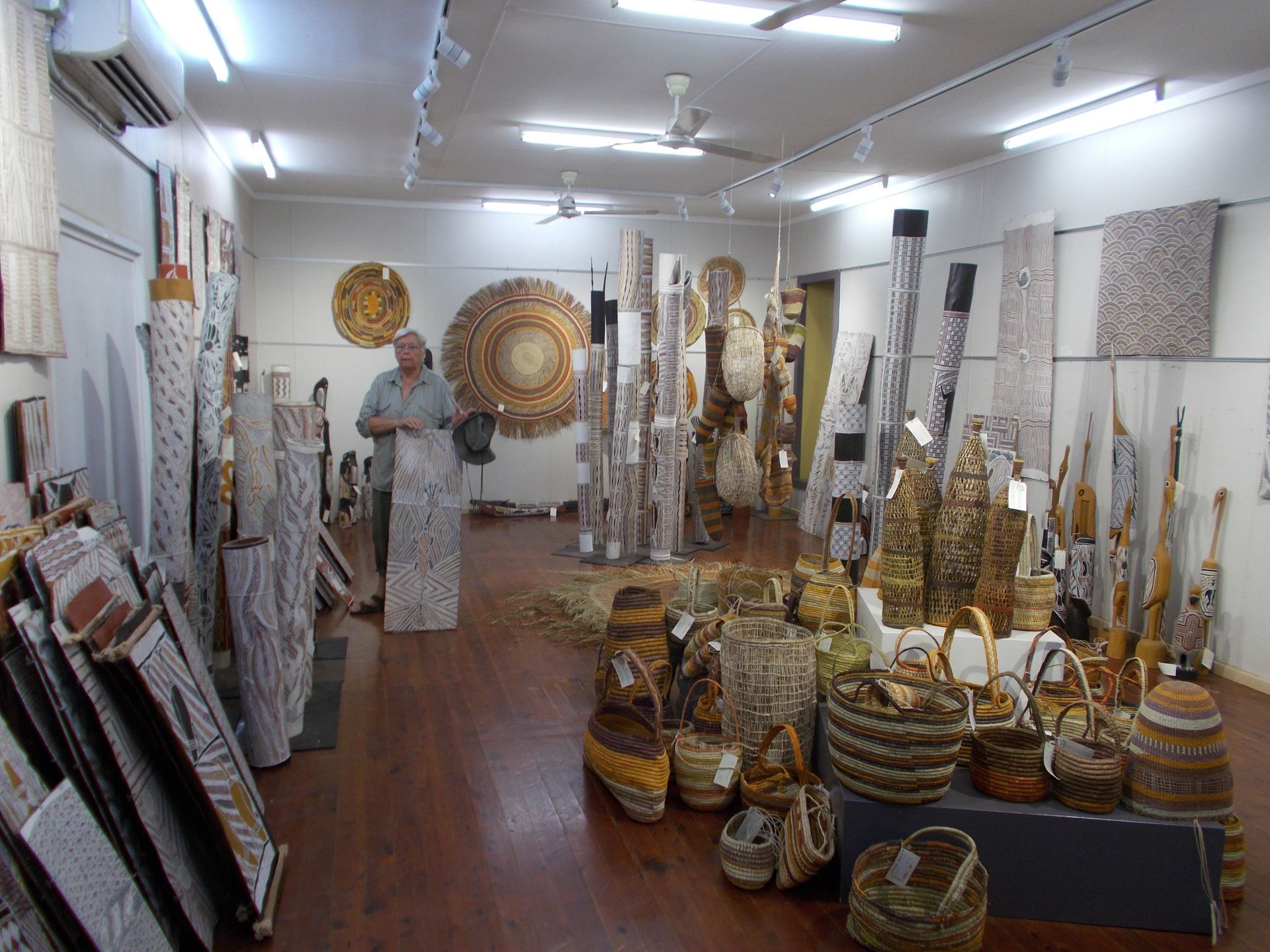 A man is standing in a room filled with lots of baskets.
