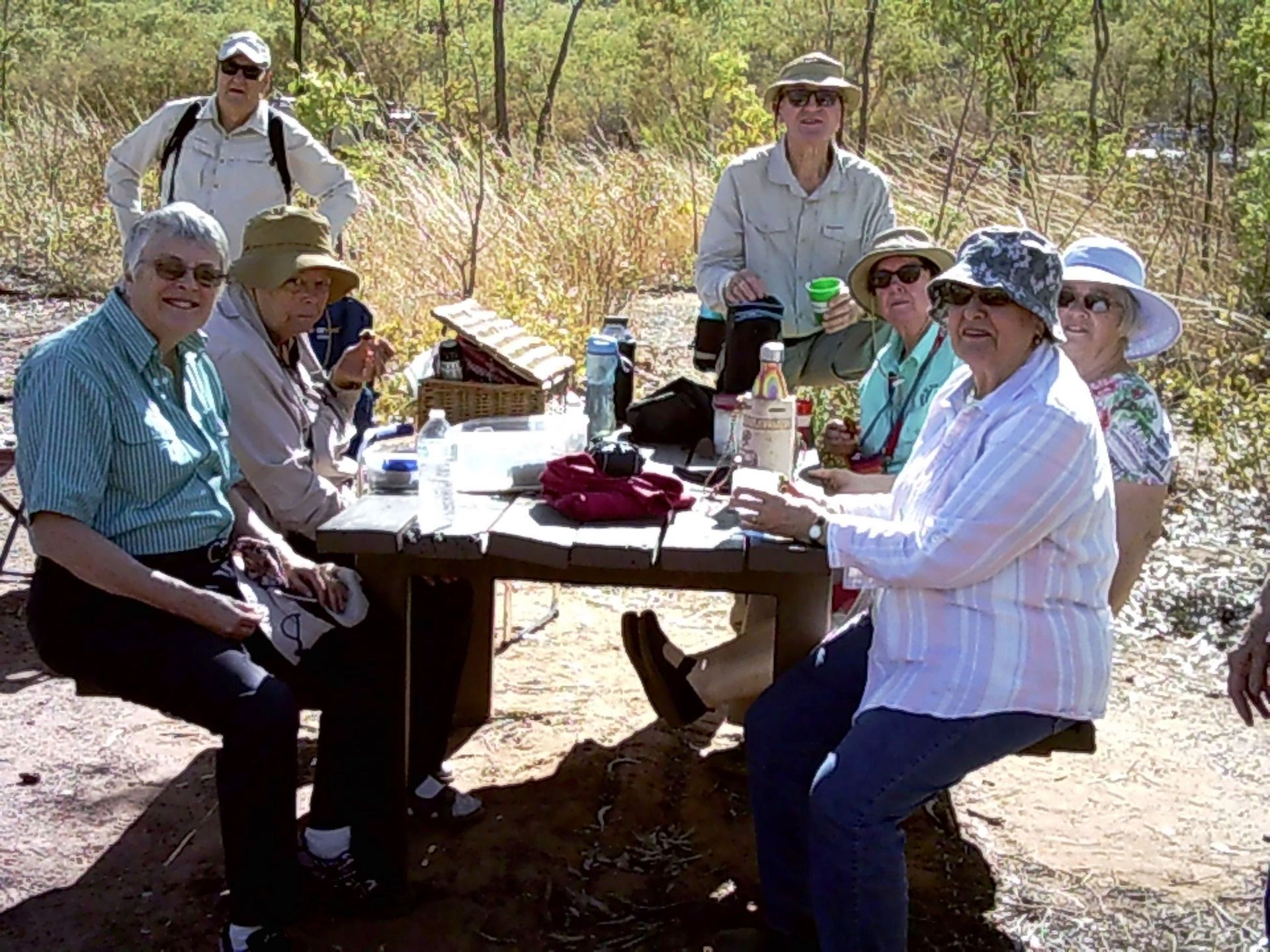 A group of people are sitting around a picnic table