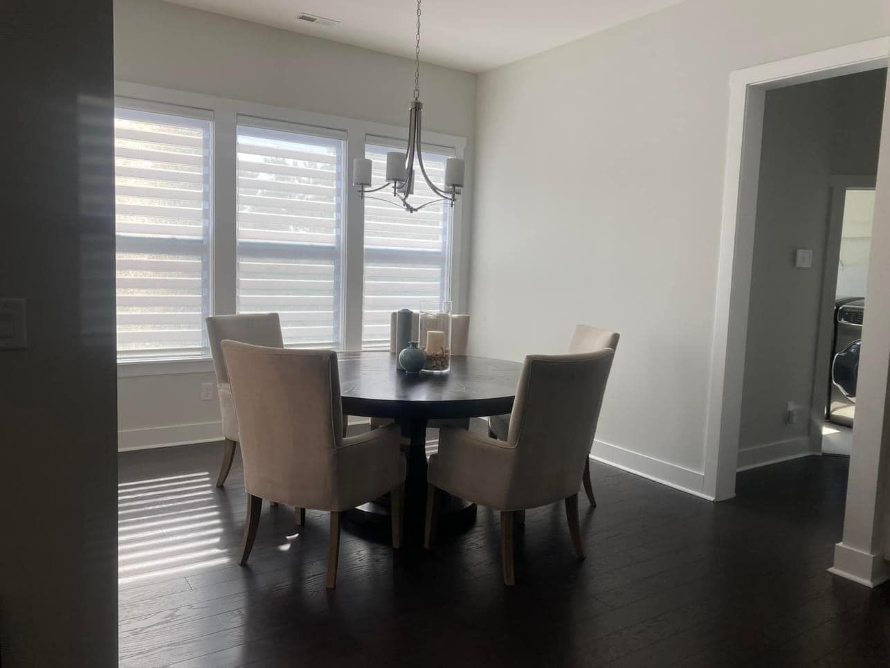 A dining room with a table and chairs and a chandelier