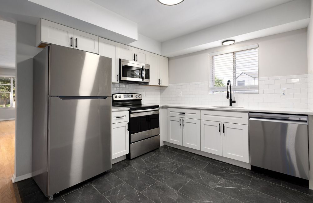 A kitchen with stainless steel appliances and white cabinets