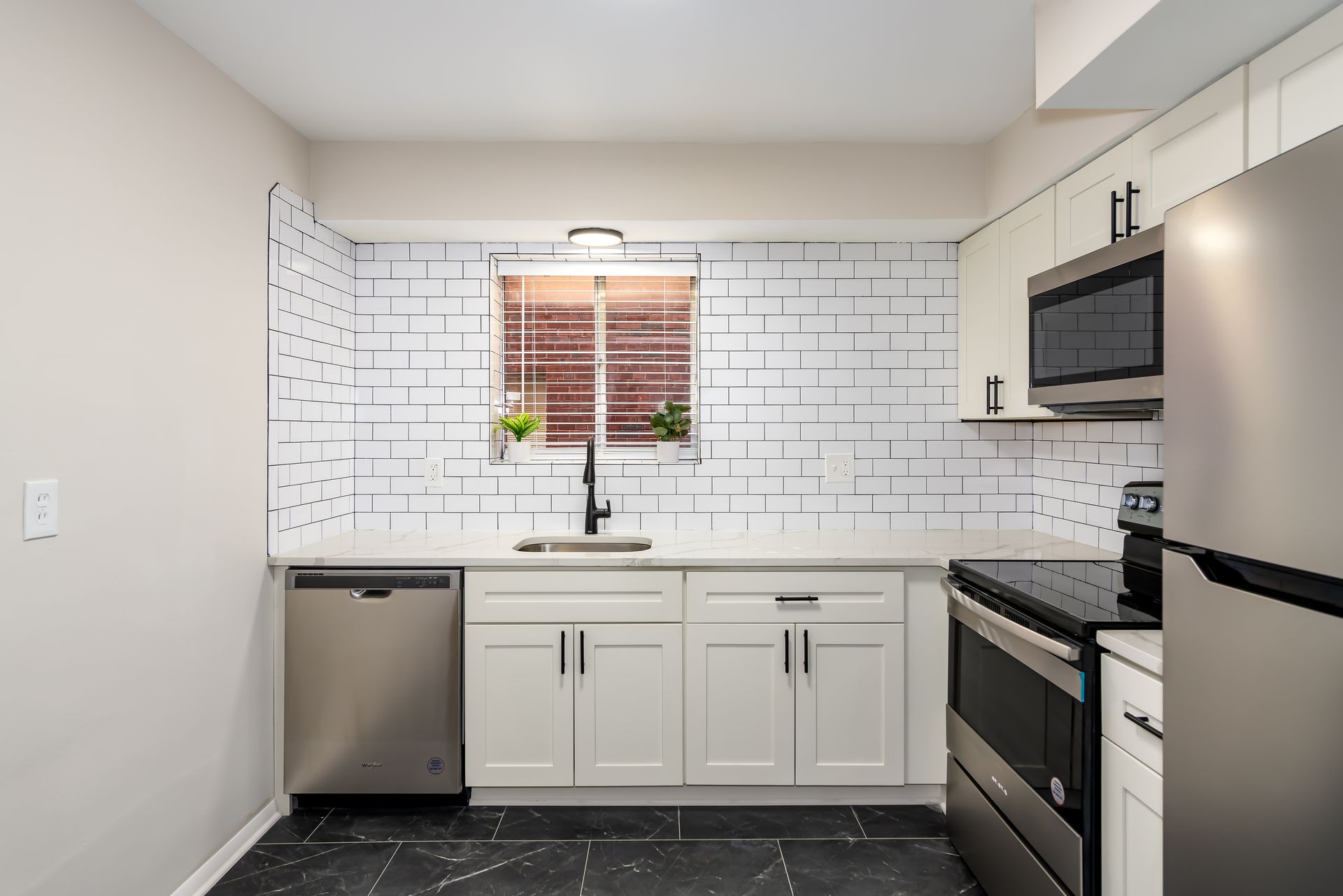 A kitchen with white cabinets and stainless steel appliances