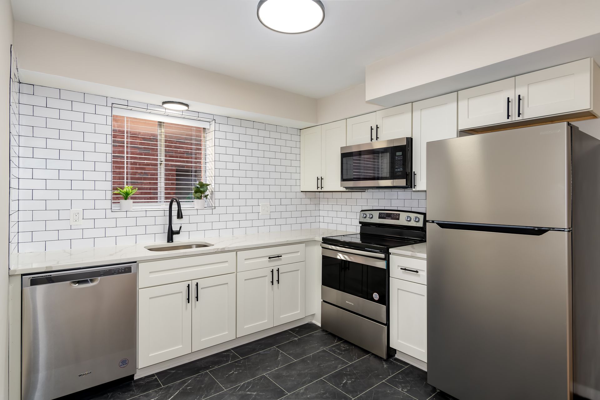 A kitchen with stainless steel appliances and white cabinets