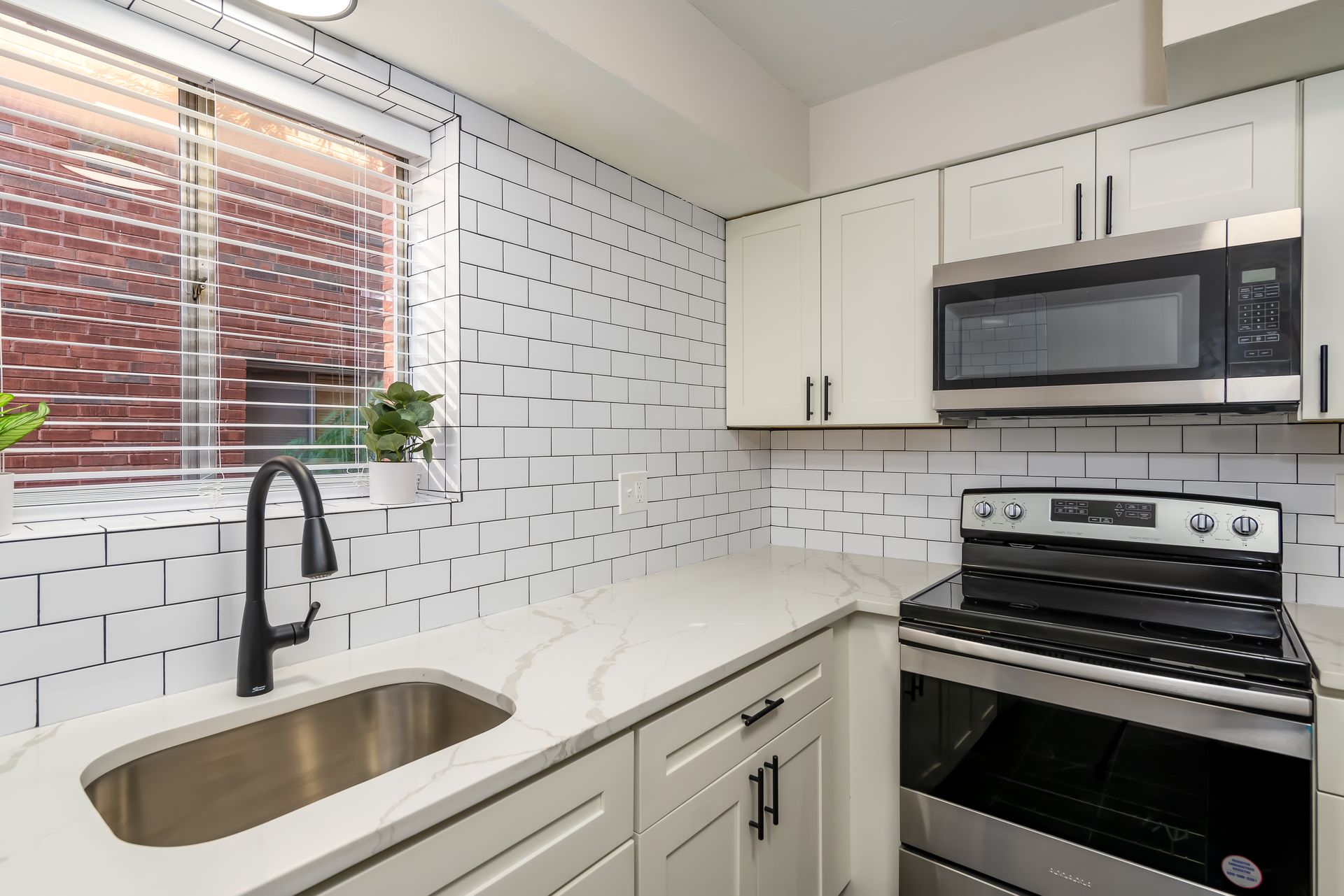 A kitchen with stainless steel appliances and white cabinets