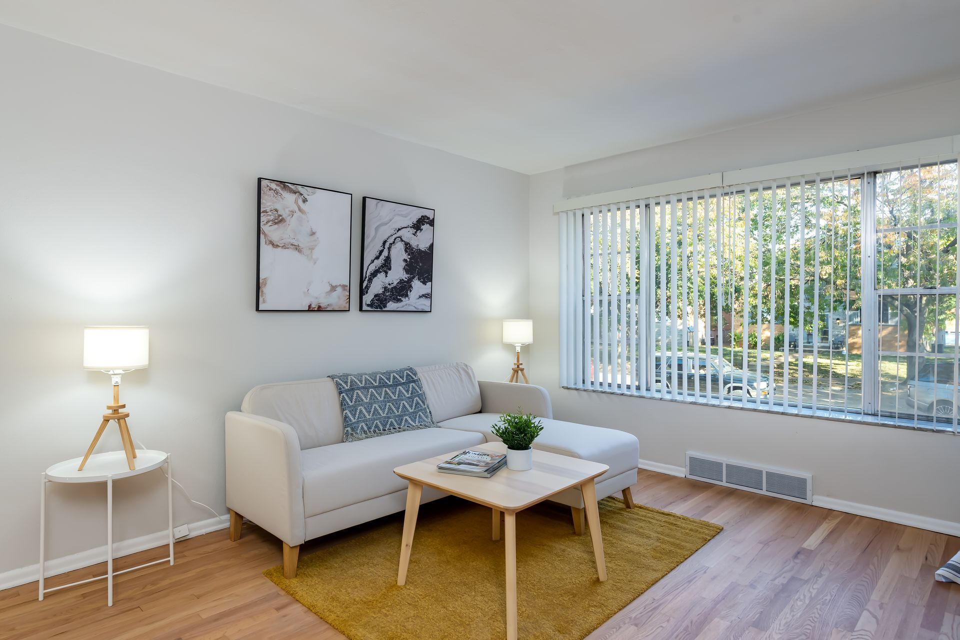 A living room with a couch , coffee table , and large window.
