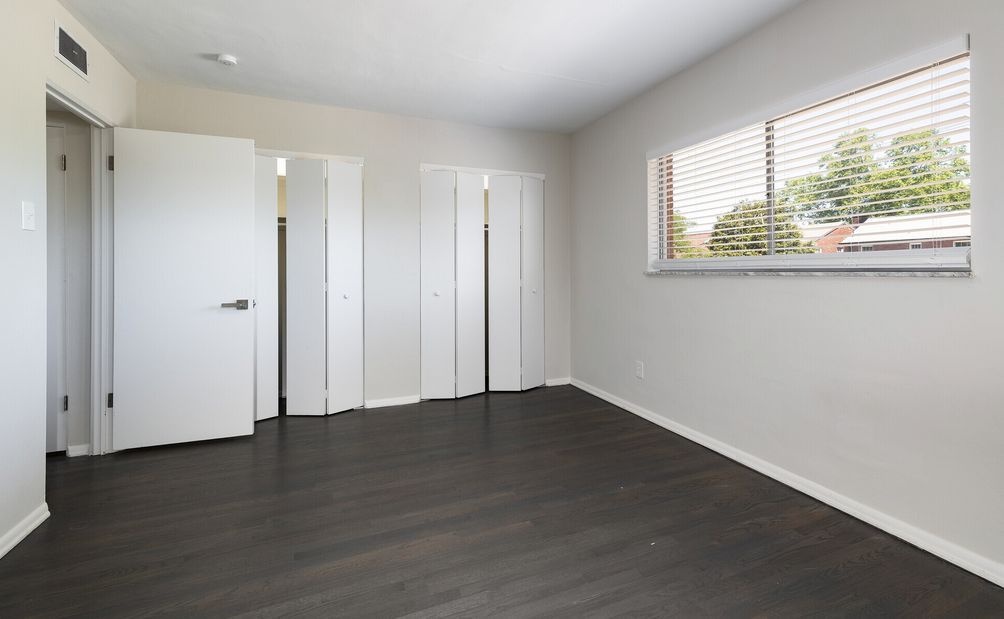 An empty room with a window and blinds on the window