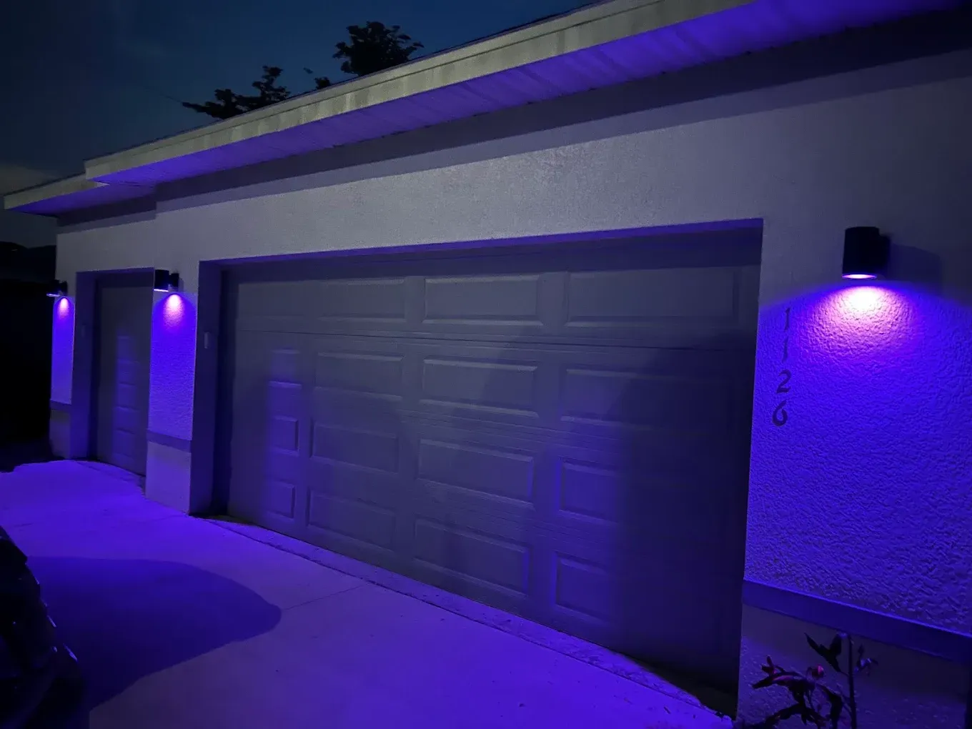 Garage with purple LED lights illuminating the exterior at dusk.