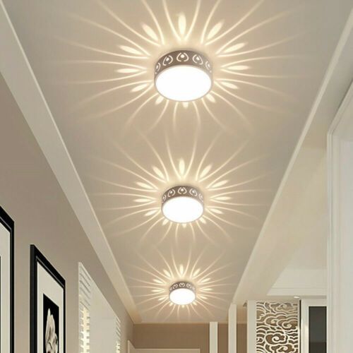 Three recessed ceiling lights casting starburst patterns in a hallway.