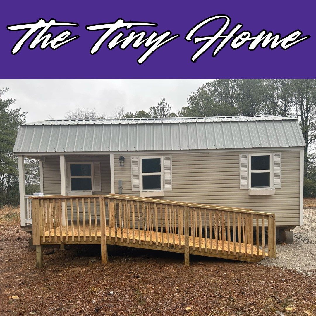 A small house with a ramp and the words the tiny home