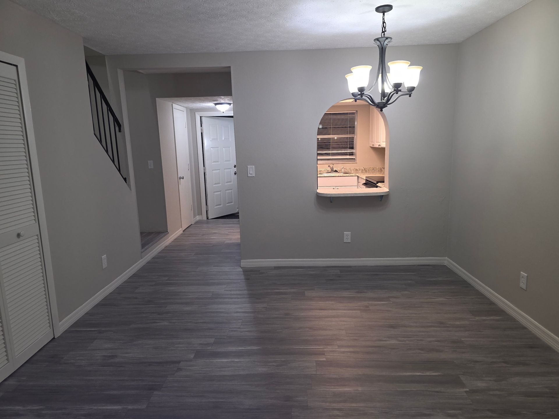 Person tiling a room with white marble-look tiles; buckets of supplies, wall with plaster near window.